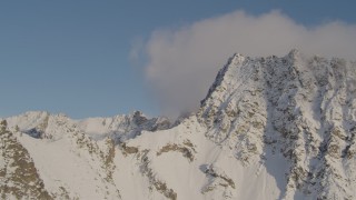 4K aerial stock footage passing snow covered peak, capped by clouds, Chugach Mountains, Alaska Aerial Stock Footage | AK0001_0295