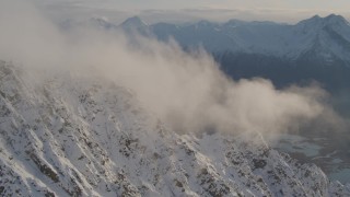 4K aerial stock footage snowy slopes, clouds, Knik River Valley, Knik Glacier, Chugach Mountains, Alaska Aerial Stock Footage | AK0001_0296