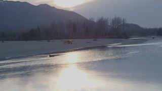 4K aerial stock footage flying low by a small plane on the shore of the river, Knik River, Alaska, sunset Aerial Stock Footage | AK0001_0310