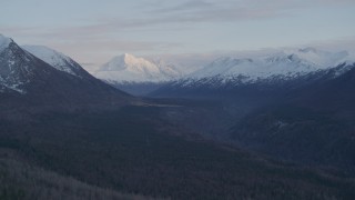 4K aerial stock footage flying by valley bordered by snowy Chugach Mountains, Alaska, twilight Aerial Stock Footage | AK0001_0317