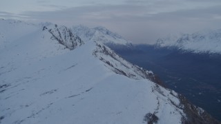 4K aerial stock footage snowy Chugach Mountain range, Eagle River Valley, Eagle River, Alaska, twilight Aerial Stock Footage | AK0001_0329