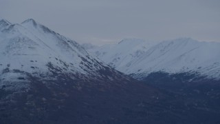 4K aerial stock footage flying by snow capped Chugach Mountains, Alaska, twilight Aerial Stock Footage | AK0001_0330