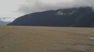 AK0001_0374 - 4K aerial stock footage flying low over grassland, approaching Kenai Mountains, Portage, Alaska