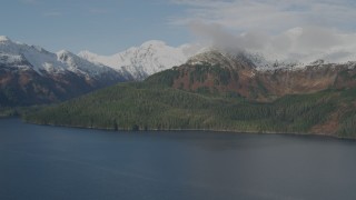 4K aerial stock footage forested shoreline, snow capped Chugach Mountains, Prince William Sound, Alaska Aerial Stock Footage | AK0001_0408