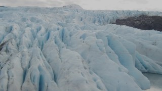 4K aerial stock footage flying over edge of glacier spilling into small lake, Prince William Sound, Alaska Aerial Stock Footage | AK0001_0449