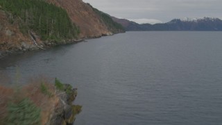 AK0001_0487 - 4K aerial stock footage flying by steep slope of mountain peak on shore, Blackstone Bay, Alaska