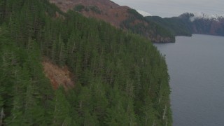 AK0001_0490 - 4K aerial stock footage flying along steep slope of a mountain peak on coast, Blackstone Bay, Alaska