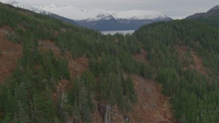 AK0001_0493 - 4K aerial stock footage flying over wooded hills, revealing Shotgun Cove, barge, Blackstone Bay, Alaska