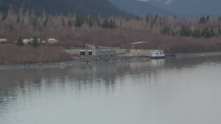 4K aerial stock footage flying low over water, by a docked boat, Portage Lake, Alaska Aerial Stock Footage | AK0001_0507