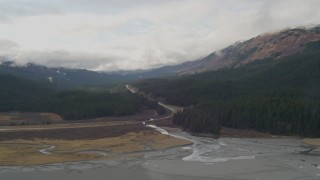 4K aerial stock footage flying by Seward Highway cutting through forest in the valley, Portage, Alaska Aerial Stock Footage | AK0001_0523