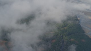 4K aerial stock footage bird's eye view over clouds, river valley, wooded foothills, Kenai Mountains, Alaska Aerial Stock Footage | AK0001_0531