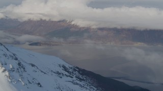 4K aerial stock footage snowy summit, reveal Turnagain Arm of the Cook Inlet, Kenai Mountains, Alaska Aerial Stock Footage | AK0001_0543