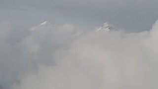 4K aerial stock footage flying over low clouds, approaching snowy summits, Chugach Mountains, Alaska Aerial Stock Footage | AK0001_0556