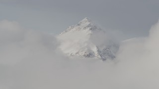 4K aerial stock footage approaching a snow covered peak, low clouds, Chugach Mountains, Alaska Aerial Stock Footage | AK0001_0557