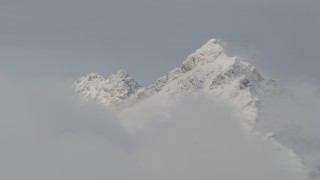 4K aerial stock footage approaching snow covered peaks, low clouds, Chugach Mountains, Alaska Aerial Stock Footage | AK0001_0560