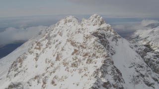 4K aerial stock footage flying along a snowy ridge, over the summit, Chugach Mountains, Alaska Aerial Stock Footage | AK0001_0565