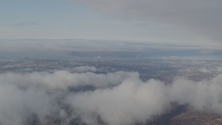 4K aerial stock footage flying by low clouds over Anchorage, from Chugach Mountains, Anchorage, Alaska Aerial Stock Footage | AK0001_0567