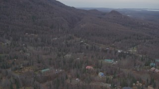 AK0001_0649 - 4K aerial stock footage flying over homes, wooded foothills, tilt down, Birchwood, Alaska