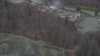 AK0001_0651 - 4K aerial stock footage approaching rock quarry, tilt down to heavy equipment and buildings, Chugiak, Alaska