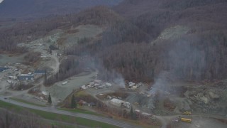 4K aerial stock footage flying away from a quarry, wooded hills, Chugiak, Alaska Aerial Stock Footage | AK0001_0652