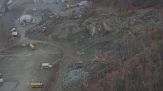 4K aerial stock footage orbiting a rock quarry near road, wooded hillside, Chugiak, Alaska Aerial Stock Footage | AK0001_0653