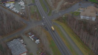 AK0001_0660 - 4K aerial stock footage tracking, passing school bus on Old Glenn Highway, tilt up to reveal Chugiak, Alaska