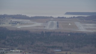 4K aerial stock footage tracking a military jet taking off, Elmendorf Air Force Base, Anchorage, Alaska Aerial Stock Footage | AK0001_0667