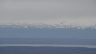 AK0001_0670 - 4K aerial stock footage E-3 Sentry coming in for landing, snowy mountains, Fort Richardson, Alaska