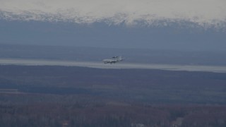 4K aerial stock footage tracking E-3 Sentry  landing, snowy mountains, Fort Richardson, Alaska Aerial Stock Footage | AK0001_0671