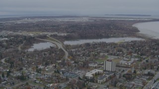 4K aerial stock footage flying over residential buildings to Westchester Lagoon, Anchorage, Alaska Aerial Stock Footage | AK0001_0676