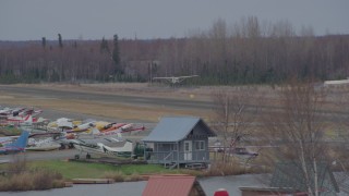 4K aerial stock footage tracking small plane taking off, Lake Hood Seaplane Base, Anchorage, Alaska Aerial Stock Footage | AK0001_0686