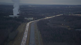 4K aerial stock footage flying away from heavy traffic, during winter, on Glenn Highway, Alaska, twilight Aerial Stock Footage | AK0001_0721