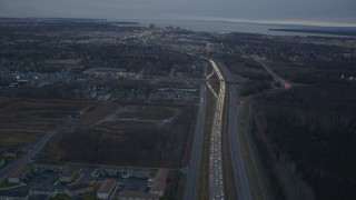 AK0001_0722 - 4K aerial stock footage following Glenn Highway, winter, revealing Downtown Anchorage, Alaska, twilight