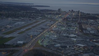 4K aerial stock footage flying over large stores by Glenn Highway, revealing Downtown Anchorage, Alaska, twilight Aerial Stock Footage | AK0001_0725