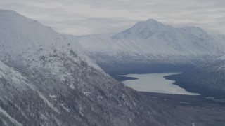 4K aerial stock footage flying by snow-covered Chugach Mountains bordering Eklutna Lake, Alaska Aerial Stock Footage | AK0001_0776