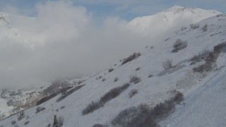 4K aerial stock footage flying by snowy slope, clouds over Chugach Mountains, Alaska Aerial Stock Footage | AK0001_0811