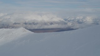 4K aerial stock footage over snowy ridge, reveal Matanuska River Valley, Chugach Mountains, Alaska Aerial Stock Footage | AK0001_0816