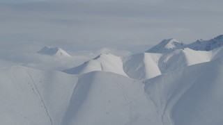 4K aerial stock footage flying by snow-covered ranges, low clouds, Chugach Mountains, Alaska Aerial Stock Footage | AK0001_0820