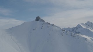 4K aerial stock footage ascend snowy slope, approach rocky, snow-covered Chugach Mountains, Alaska Aerial Stock Footage | AK0001_0824