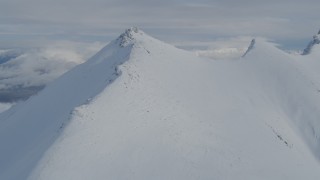 4K aerial stock footage flying by a snowy mountain ridge in the Chugach Mountains, Alaska Aerial Stock Footage | AK0001_0838