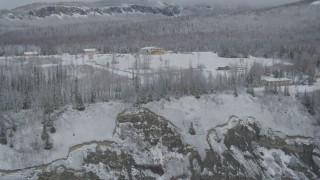 AK0001_0859 - 4K aerial stock footage ascend up rocky slope, reveal snowy King Ranch, Sutton, Alaska