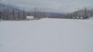 AK0001_0864 - 4K aerial stock footage flying low over snowy runway at King Ranch, and reveal Matanuska River Valley, Sutton, Alaska