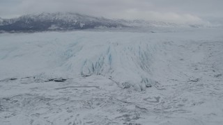 AK0001_0874 - 4K aerial stock footage approach distant snow-covered mountains, edge of Matanuska Glacier, Alaska