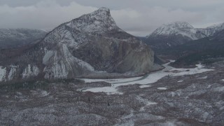 AK0001_0876 - 4K aerial stock footage flying over hills toward a snow-capped rocky peak, Matanuska River Valley, Alaska