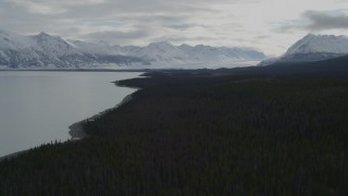 4K aerial stock footage flying beside Tazlina Lake during winter toward snow covered Tazlina Glacier, Alaska Aerial Stock Footage | AK0001_0912