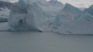 AK0001_0918 - 4K aerial stock footage flying over glacial ice, revealing snow covered Tazlina Glacier during winter, Tazlina Lake, Alaska