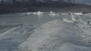 AK0001_0936 - 4K aerial stock footage flying over snow covered glacier edge, past ice in Tazlina Lake, winter, Tazlina Glacier, Alaska