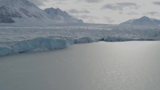 AK0001_0942 - 4K aerial stock footage flying along edge of snow covered glacier during winter, reveal ice chunk, Tazlina Lake, Alaska