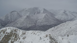 4K aerial stock footage fly over snow-covered peaks, reveal wooded valley, Chugach Mountains, Alaska Aerial Stock Footage | AK0001_0951