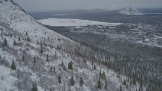 4K aerial stock footage rounding snow-covered slope, reveal Kaina Lake, Chugach Mountains, Alaska Aerial Stock Footage | AK0001_0954